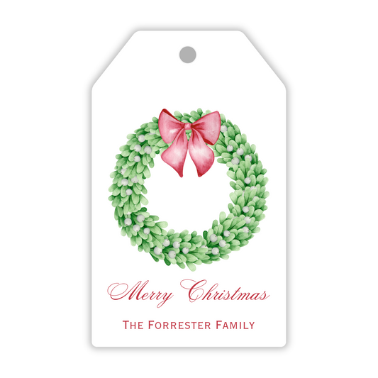 A personalized gift tag featuring a boxwood wreath with a red bow and the text 'Merry Christmas' along with a space for personalization, such as 'The Smith Family', ShooFly Paper Co. Auburn, Alabama